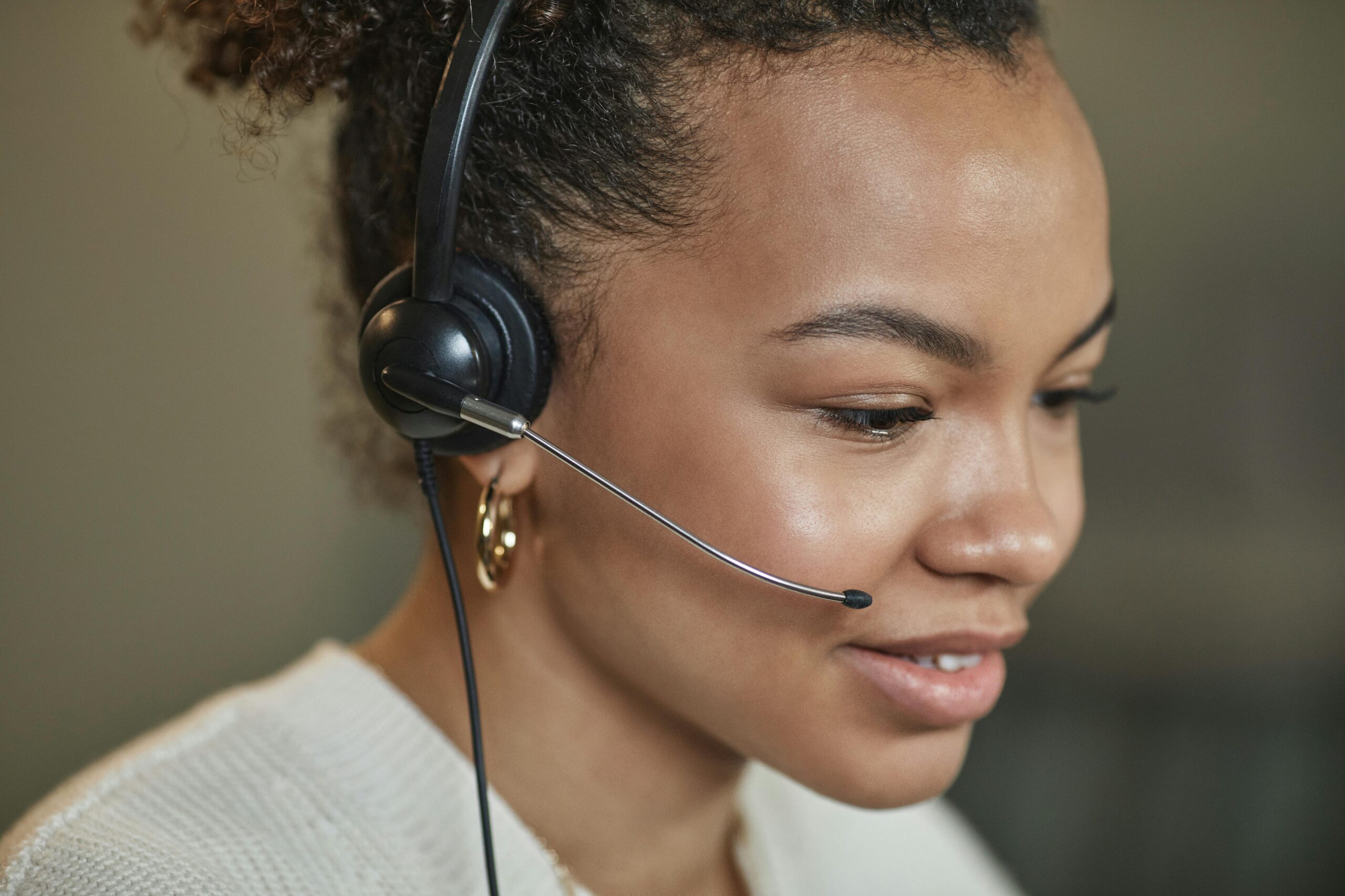 Close-up of a focused call center agent wearing a headset, working indoors.